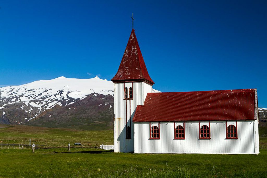 Rot-weiße Holzkirche vor Gletscher-Vulkan