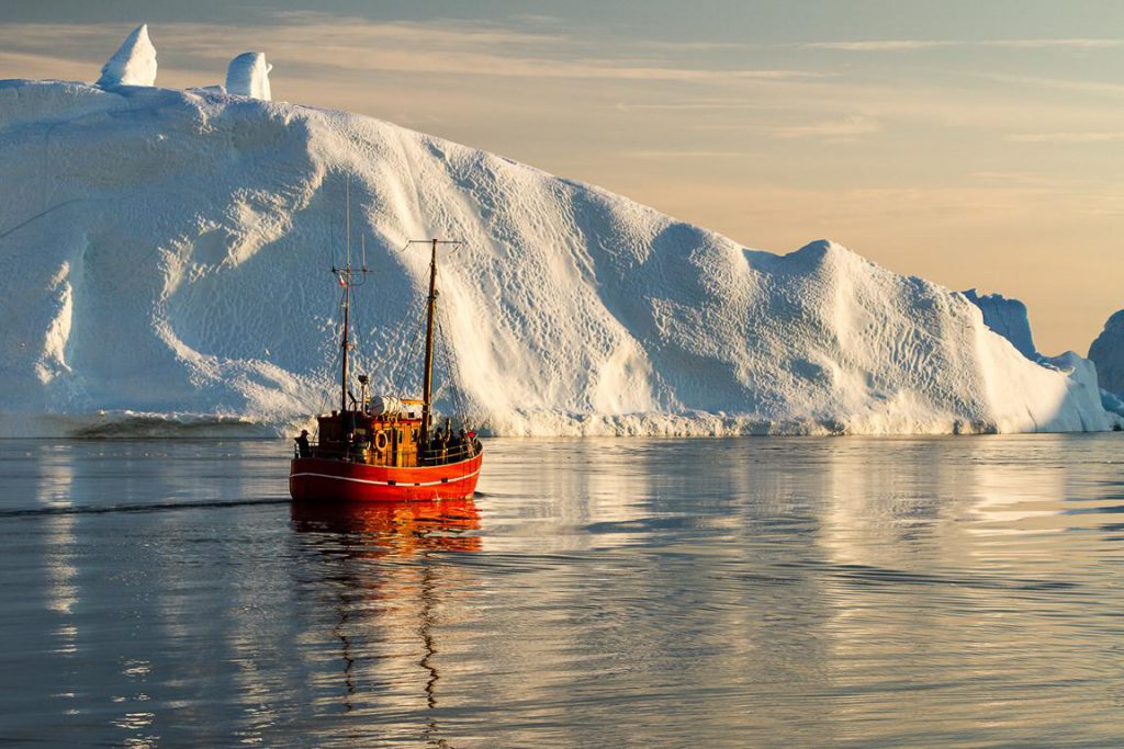 Boot vor großem Eisberg in Grönland