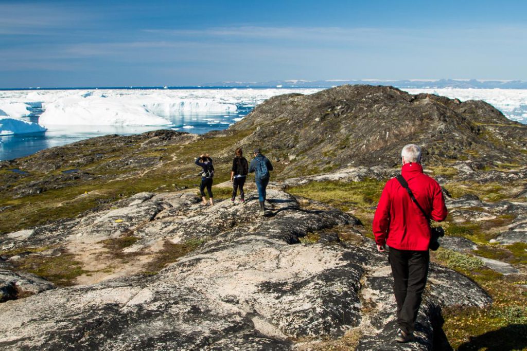 Wandergruppe an der Küste mit Eisbergen