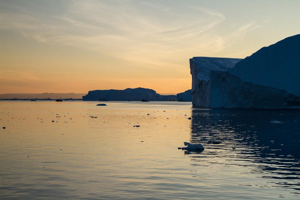 Eisberge vor orangem Himmel